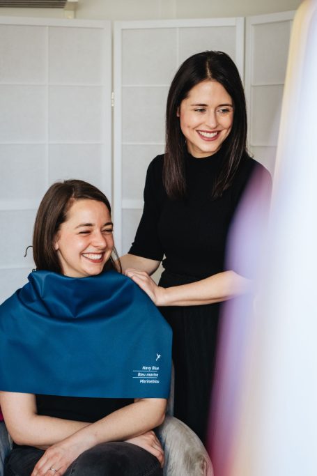 Frisörin schneidet das Haar einer zufriedenen Kundin in einem modernen Salon.